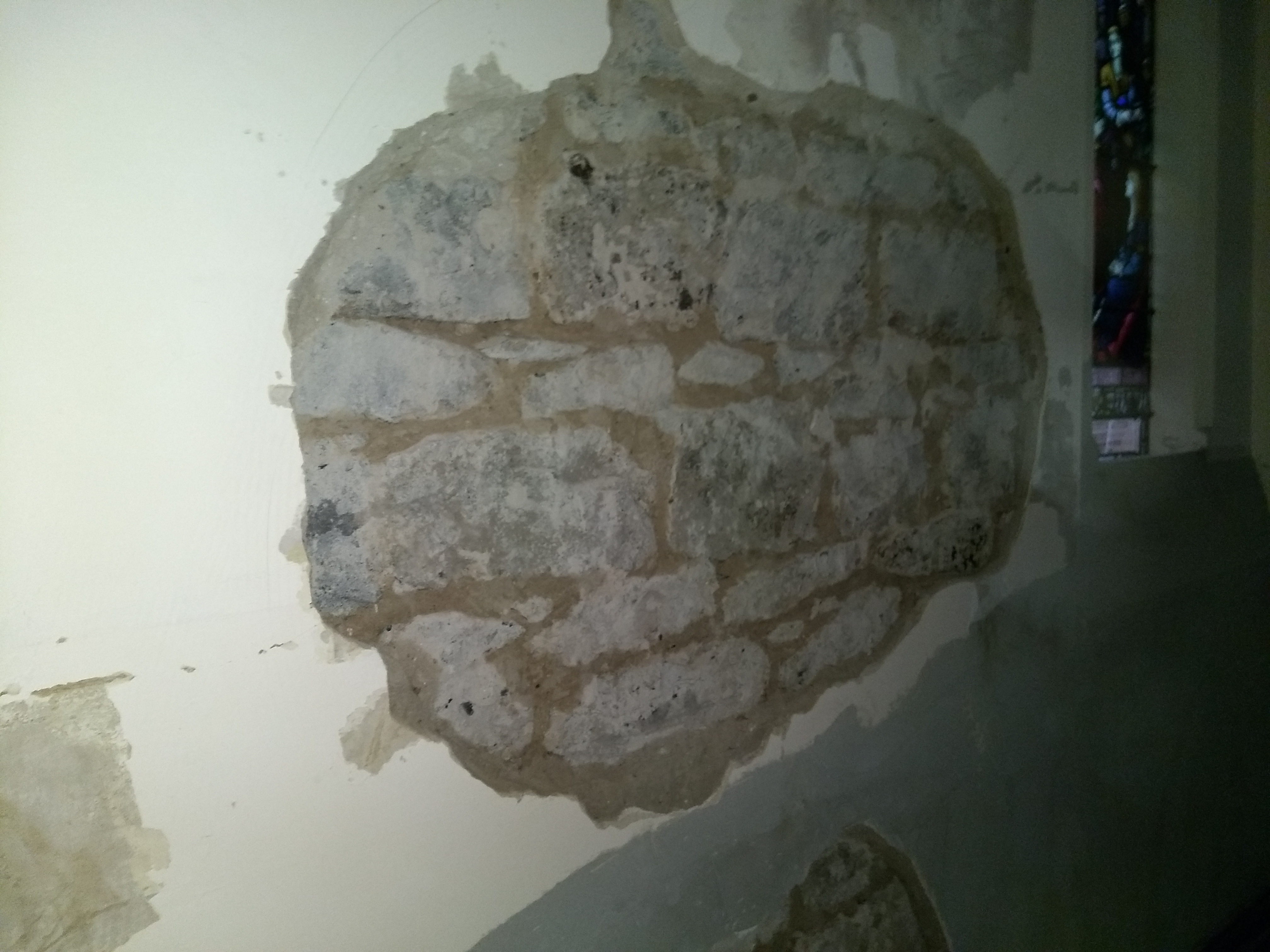 Exposed masonry after failed plaster was removed from the church wall