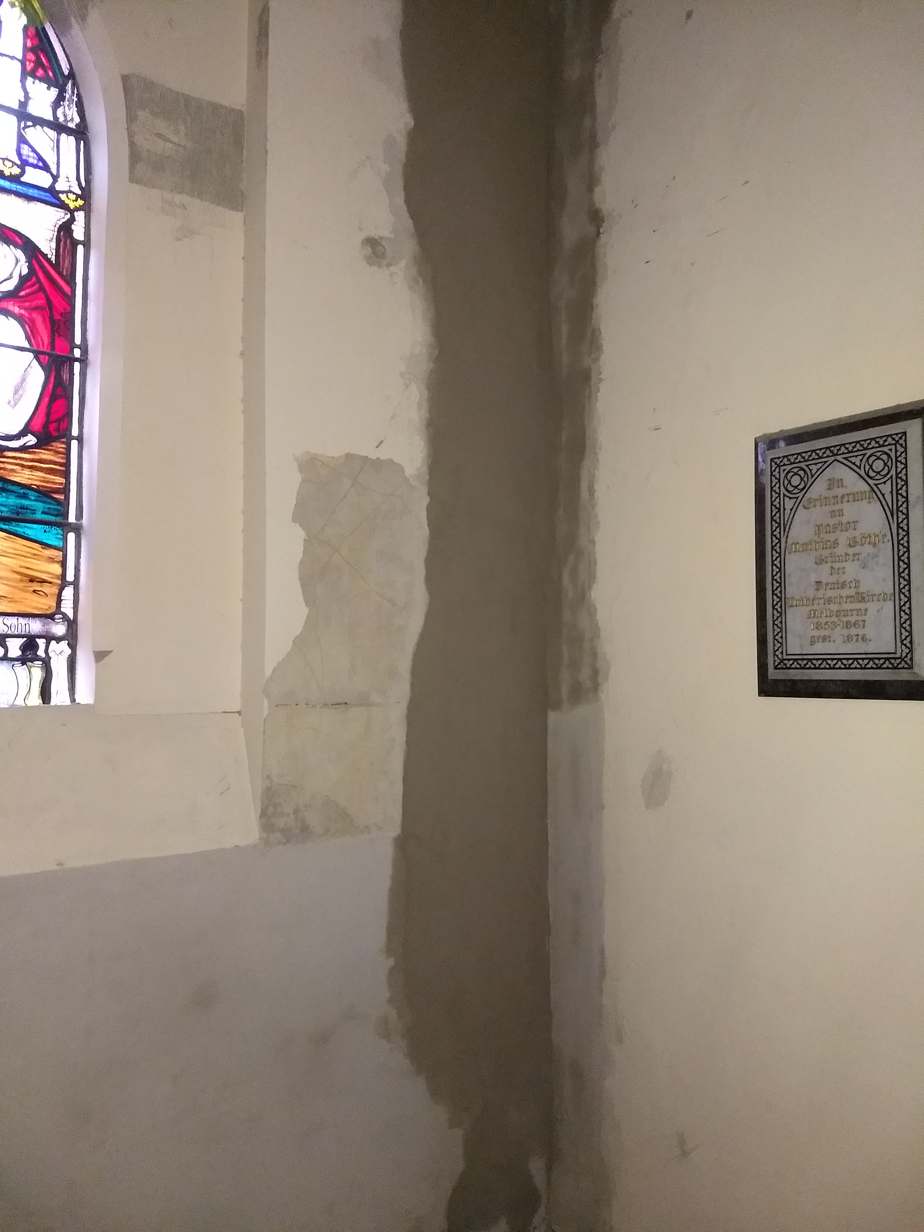 Localised repair area beside a stained glass window inside the church